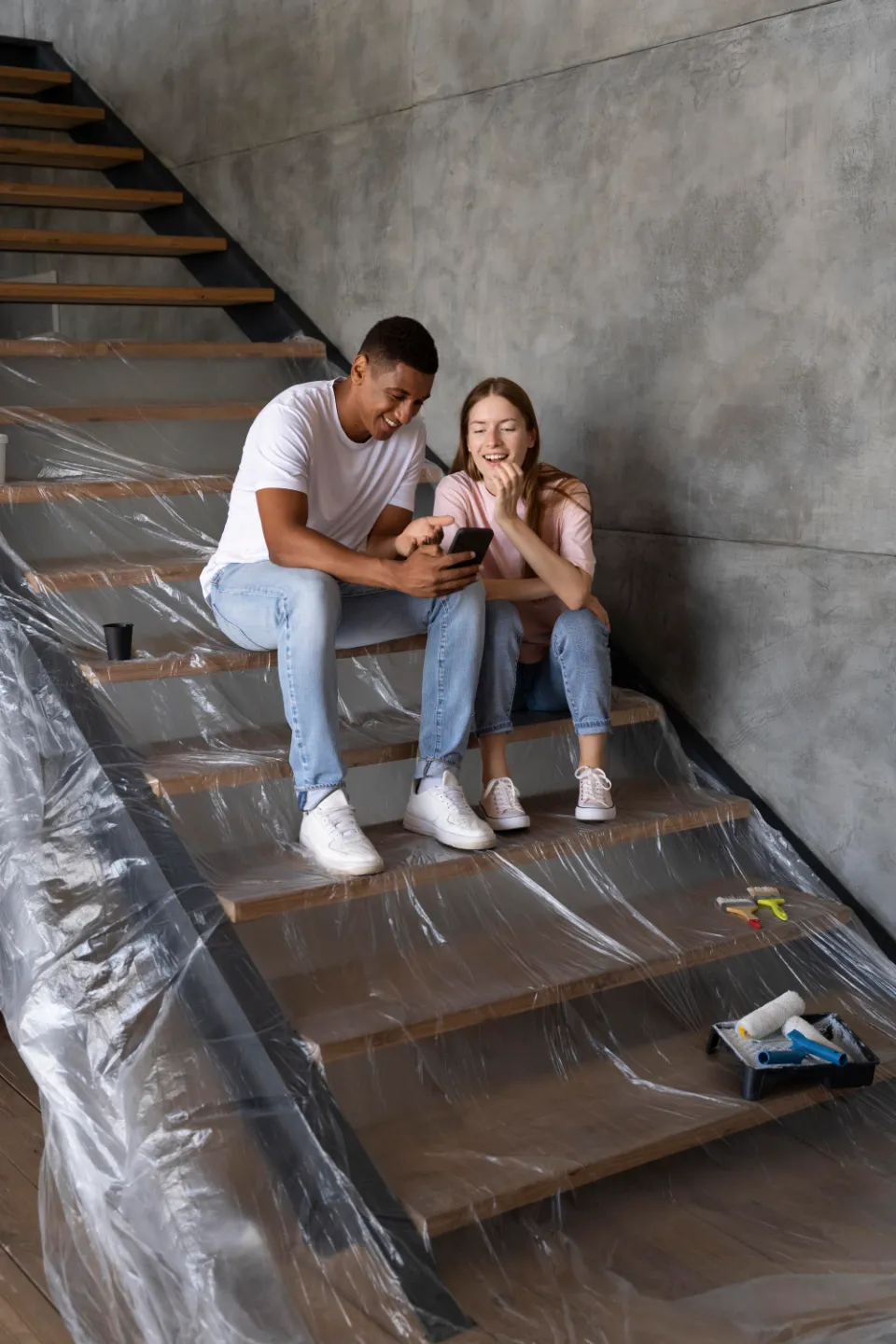 Un couple assis sur des escaliers en reflexion pour la location d'un box de stockage pendant leurs travaux